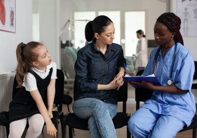 family-discussing-medical-treatment-with-african-american-nurse-in-hospital