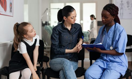 family-discussing-medical-treatment-with-african-american-nurse-in-hospital